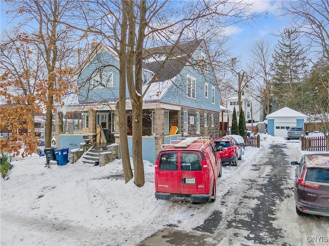 view of front of home with a garage and an outbuilding