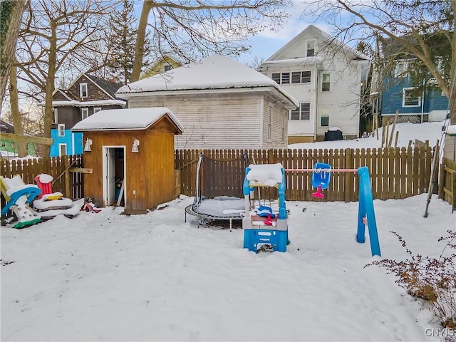 snow covered rear of property with a shed