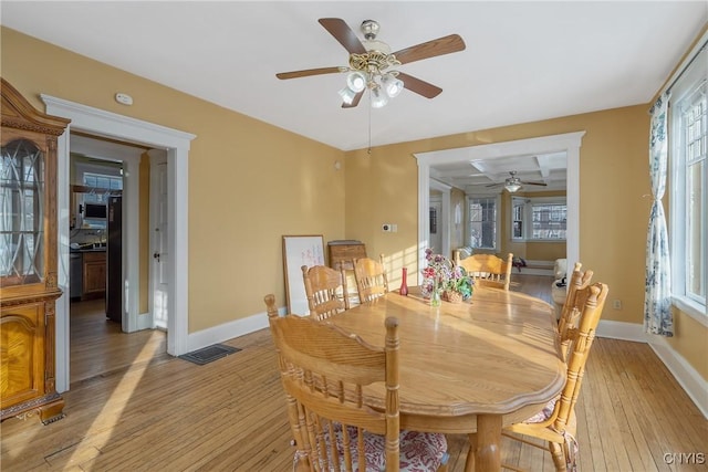 dining space with light hardwood / wood-style floors and ceiling fan