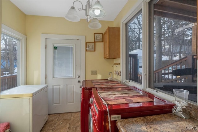 tiled dining space with plenty of natural light and a notable chandelier