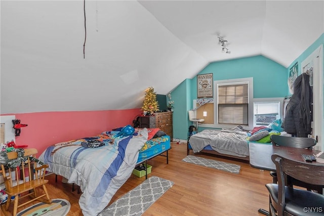 bedroom with wood-type flooring and vaulted ceiling