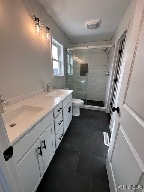 bathroom with toilet, walk in shower, and vanity