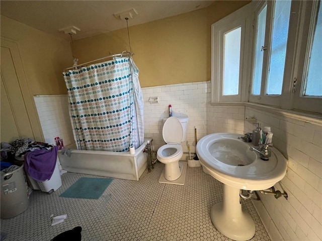 bathroom with tile walls, tile patterned flooring, toilet, and shower / bath combo