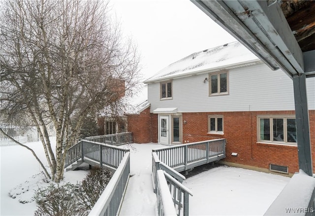 snow covered house featuring a deck