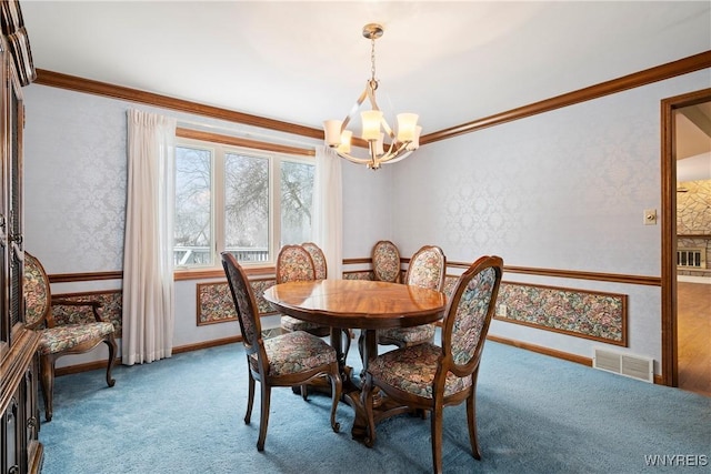 carpeted dining room with a chandelier and ornamental molding