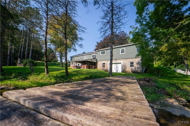 rear view of house with a lawn and a garage