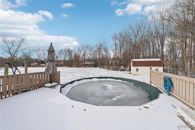 yard covered in snow with a storage shed