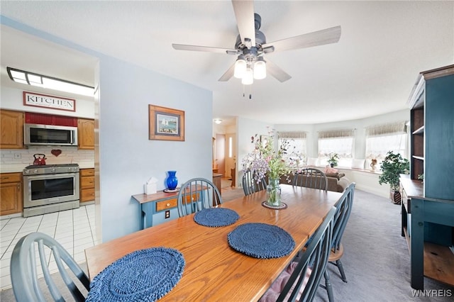 carpeted dining room with ceiling fan