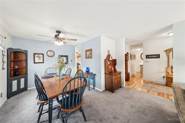 carpeted dining space with a textured ceiling and ceiling fan