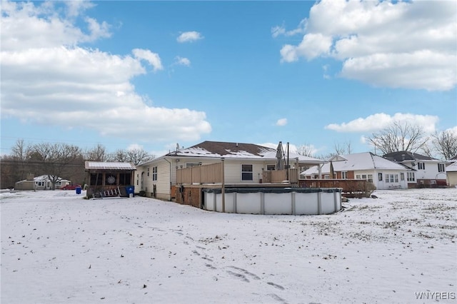 snow covered property with a covered pool