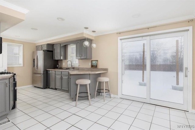 kitchen with kitchen peninsula, gray cabinets, pendant lighting, and a kitchen bar