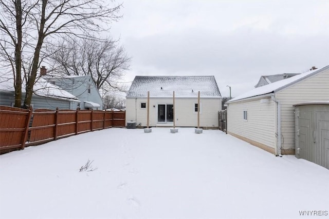 snow covered house with central AC unit