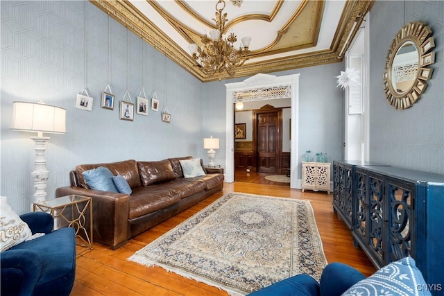 living room featuring crown molding, a chandelier, and hardwood / wood-style floors