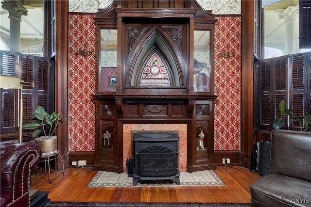 sitting room with hardwood / wood-style flooring and a wood stove