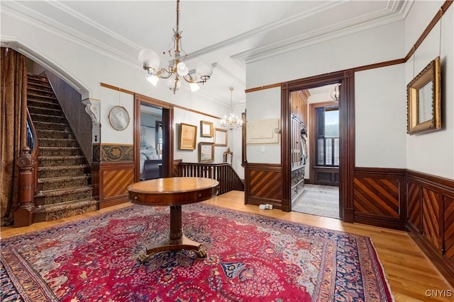 entryway featuring hardwood / wood-style floors, crown molding, and a chandelier