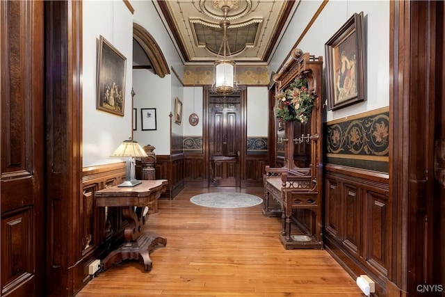 living area featuring ornamental molding, light hardwood / wood-style flooring, and a raised ceiling