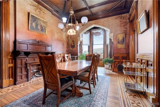 dining room featuring a notable chandelier, light hardwood / wood-style floors, crown molding, and wood ceiling