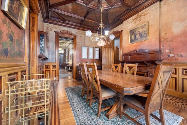 dining room with light hardwood / wood-style flooring, a notable chandelier, wood ceiling, crown molding, and coffered ceiling