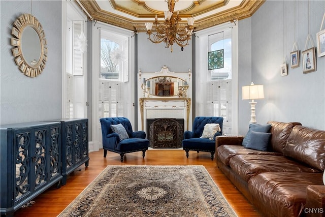 sitting room with an inviting chandelier, crown molding, and wood-type flooring