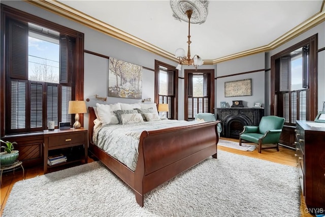 bedroom with an inviting chandelier, multiple windows, and light hardwood / wood-style floors