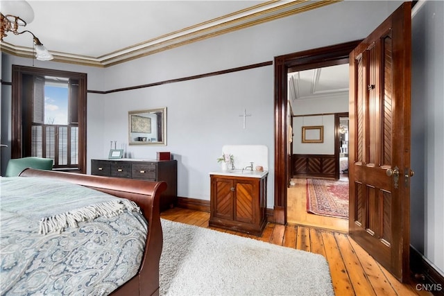 bedroom with light hardwood / wood-style floors and crown molding