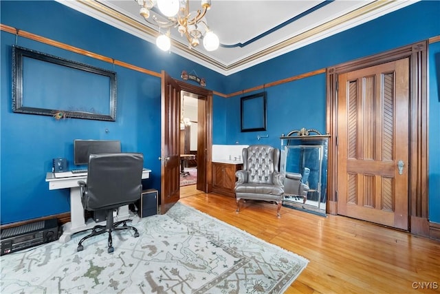 office area with a notable chandelier, crown molding, and wood-type flooring