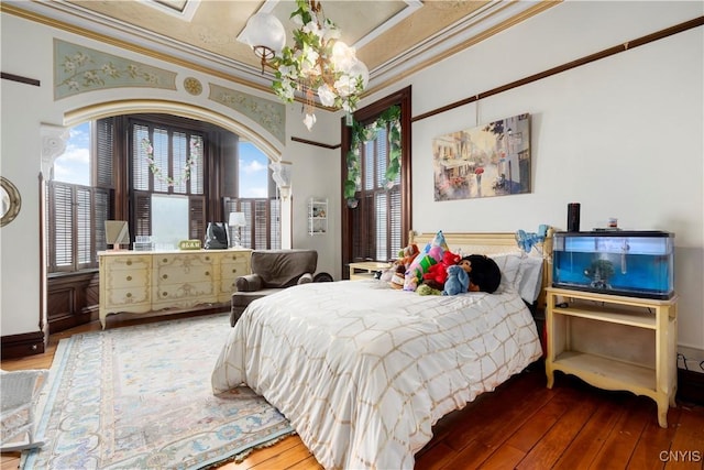 bedroom with ornamental molding and hardwood / wood-style floors