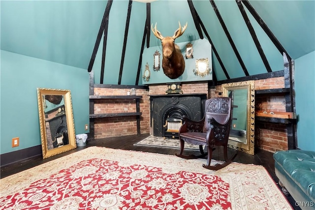 sitting room featuring hardwood / wood-style floors, lofted ceiling, and a wood stove