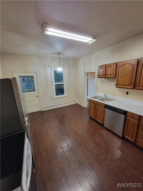 kitchen featuring sink, dark hardwood / wood-style floors, a baseboard radiator, pendant lighting, and appliances with stainless steel finishes