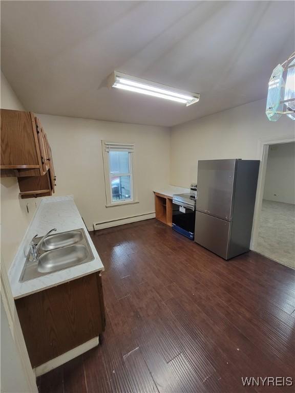 kitchen featuring stainless steel fridge, a baseboard radiator, dark hardwood / wood-style flooring, and sink