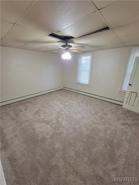 spare room with ceiling fan, a paneled ceiling, and carpet flooring