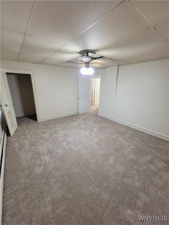 carpeted empty room with a drop ceiling and ceiling fan