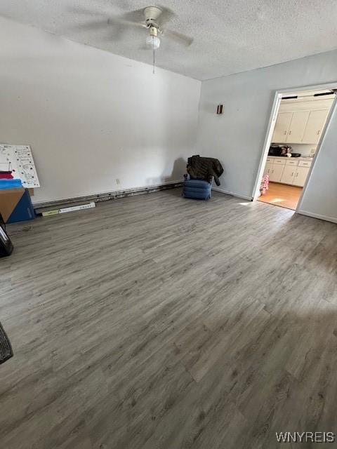 bonus room with a textured ceiling, ceiling fan, and wood-type flooring