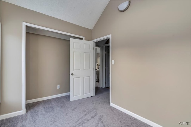 unfurnished bedroom with light carpet and lofted ceiling