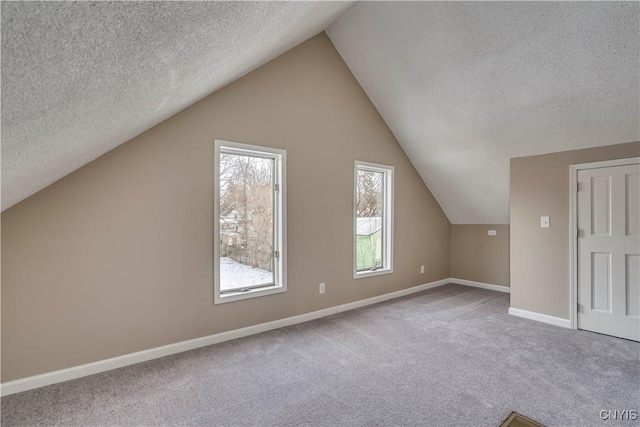 bonus room with a textured ceiling, vaulted ceiling, and carpet floors