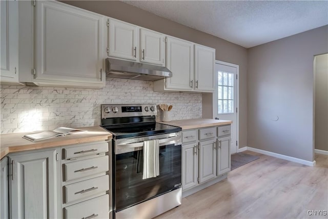 kitchen featuring a textured ceiling, stainless steel electric stove, light hardwood / wood-style floors, decorative backsplash, and white cabinets