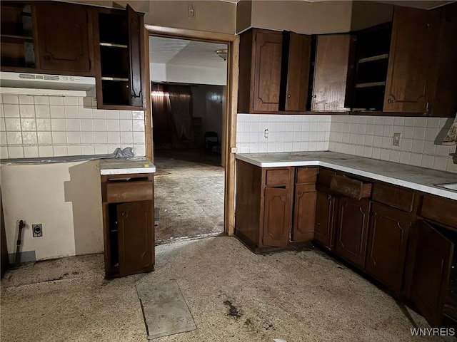 kitchen featuring backsplash and dark brown cabinetry