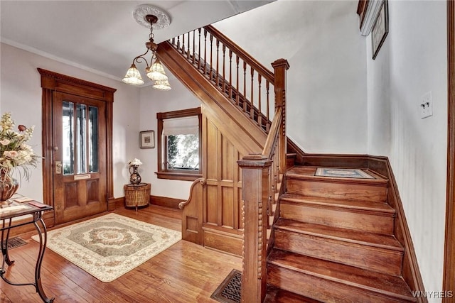 entryway with an inviting chandelier, hardwood / wood-style floors, and a wealth of natural light