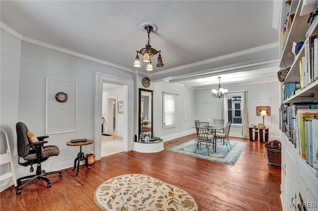 dining space featuring ornamental molding, a notable chandelier, and hardwood / wood-style flooring