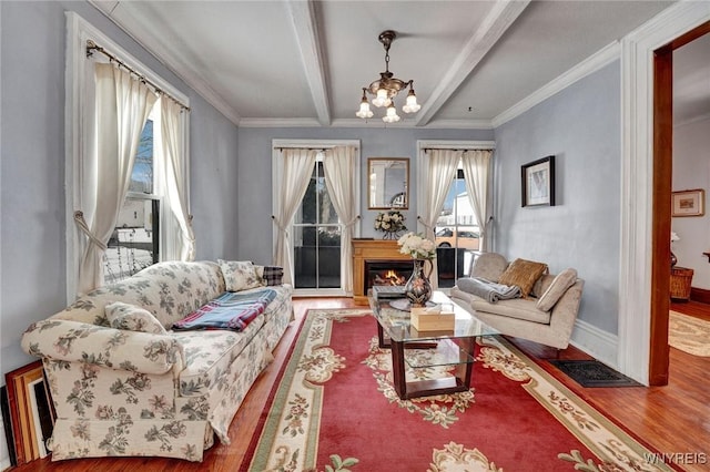 living room with hardwood / wood-style flooring, beam ceiling, a notable chandelier, and crown molding