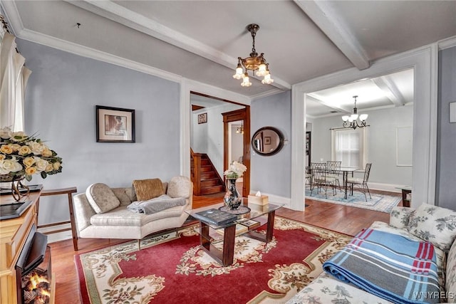 living room with beam ceiling, an inviting chandelier, crown molding, and hardwood / wood-style flooring