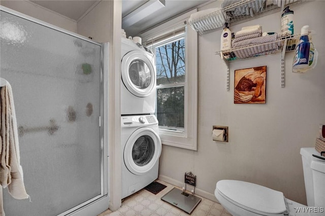 bathroom featuring toilet, stacked washer / drying machine, and a shower with shower door