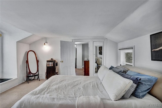 bedroom with lofted ceiling and light colored carpet