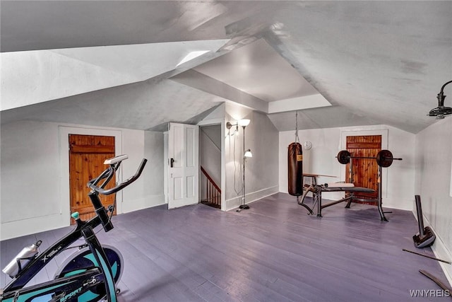 workout area with dark wood-type flooring and vaulted ceiling