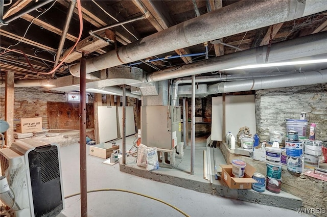 basement featuring white fridge and heating unit