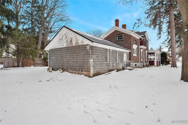 view of snow covered back of property