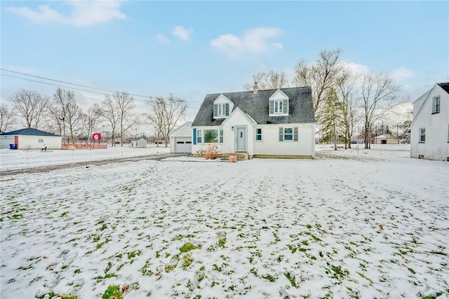 snow covered rear of property with a garage