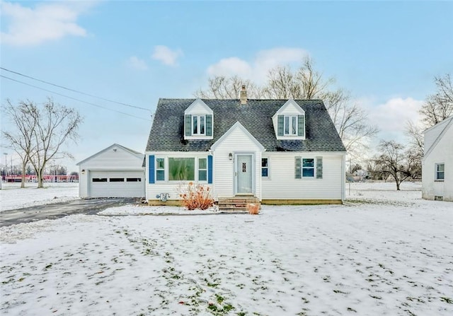 cape cod home with a garage and an outbuilding