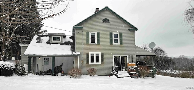 view of snow covered back of property