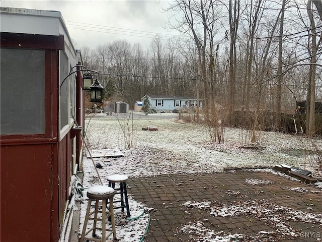 yard layered in snow with a patio